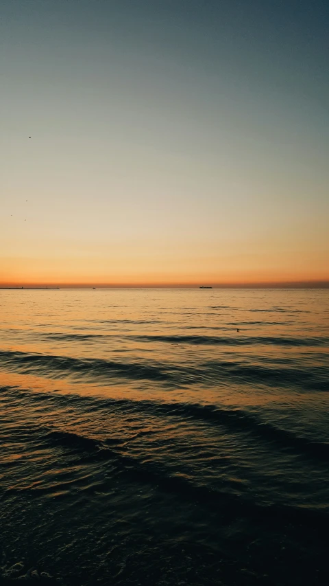 the sun rising over the horizon on the ocean