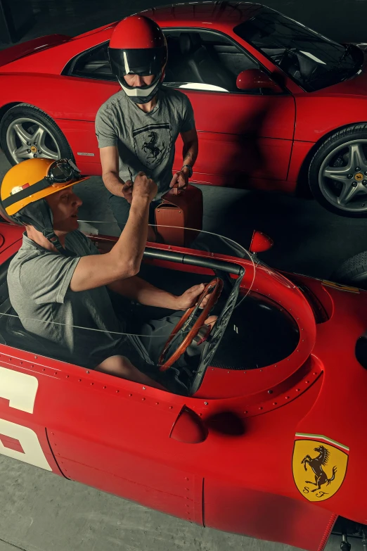 man working on the red ferrari sports car