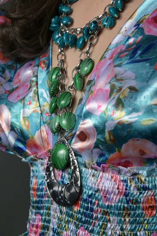 the woman wears her necklace with green and black beads