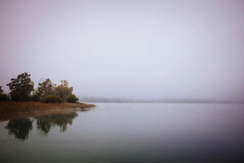 the fog on a lake looks like it is coming over