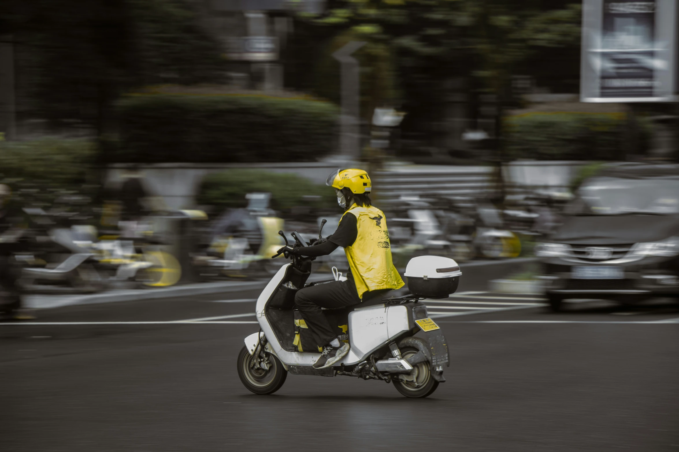 person in yellow jacket riding a small motorcycle