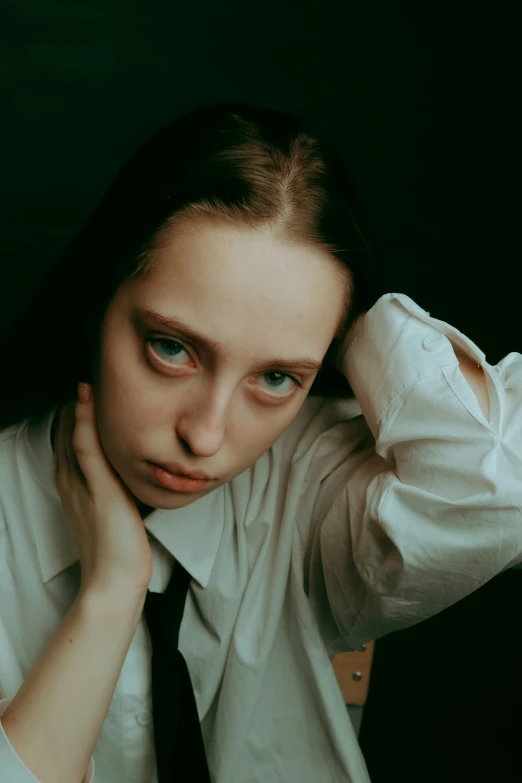 a young woman in a tie looking pensive