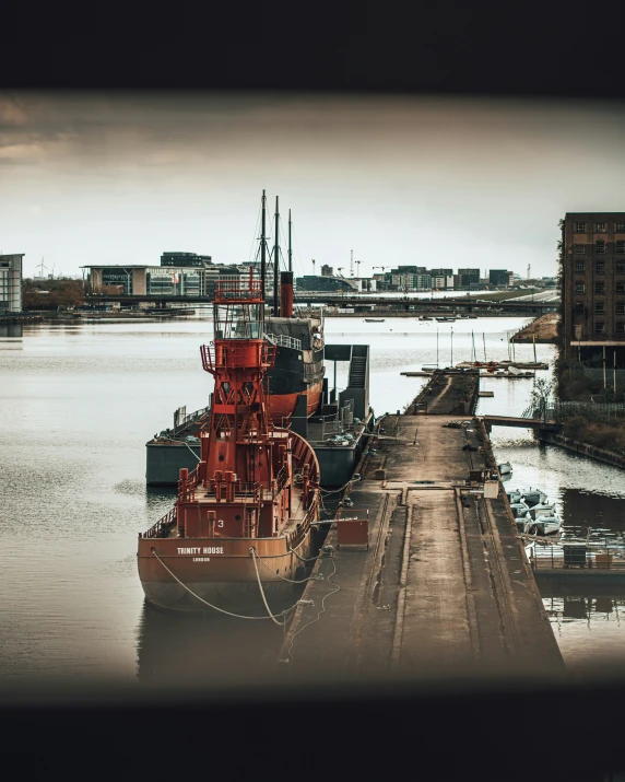 large tug boat docked near a pier on a cityscape