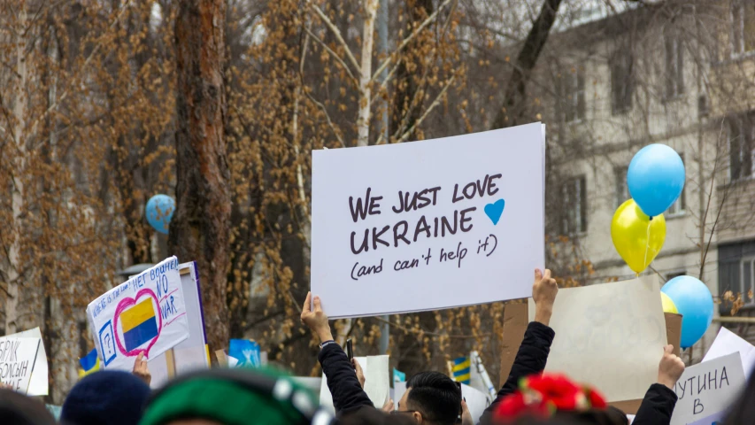 people standing together holding signs in the air