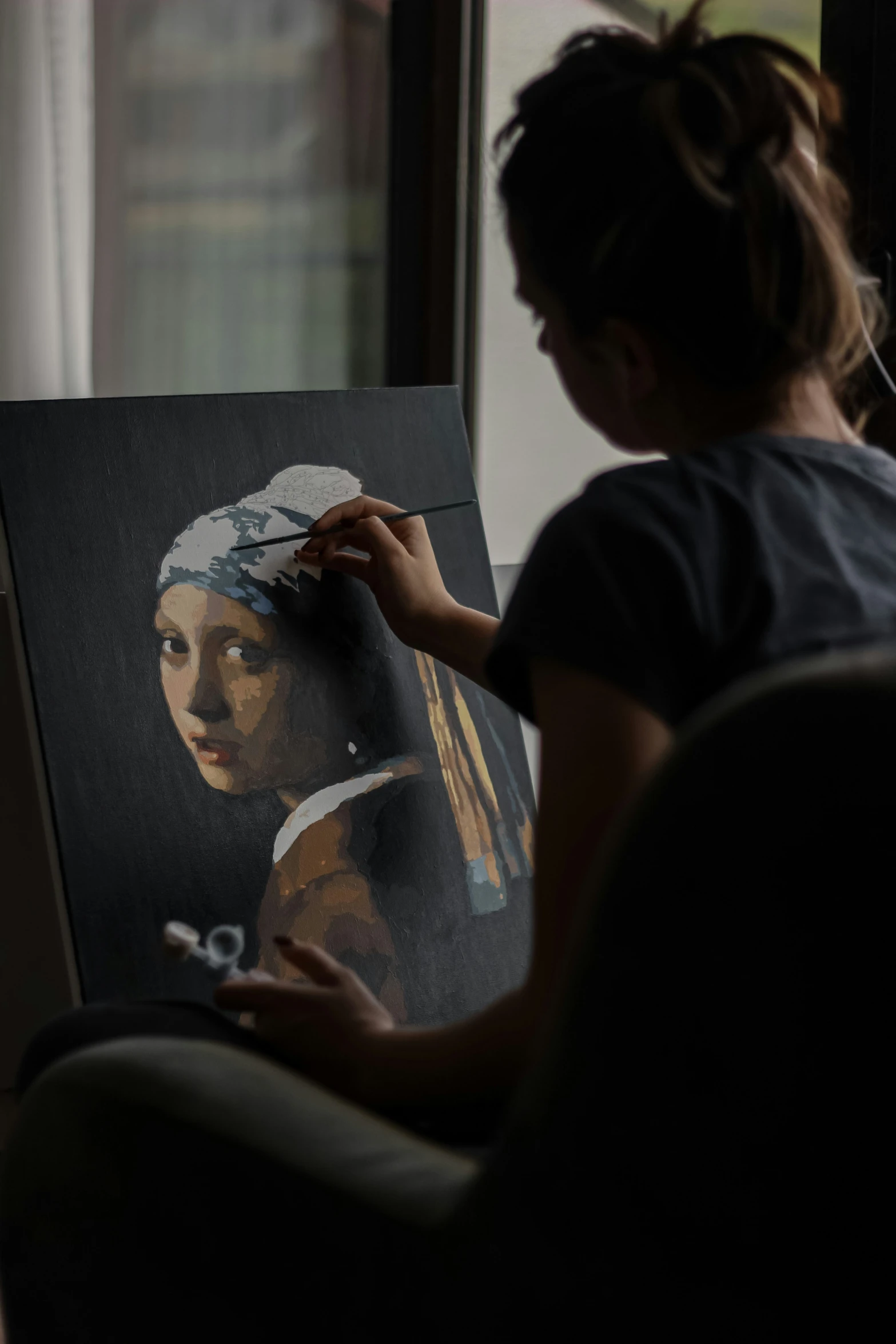 a woman sitting in front of a painting with a knife