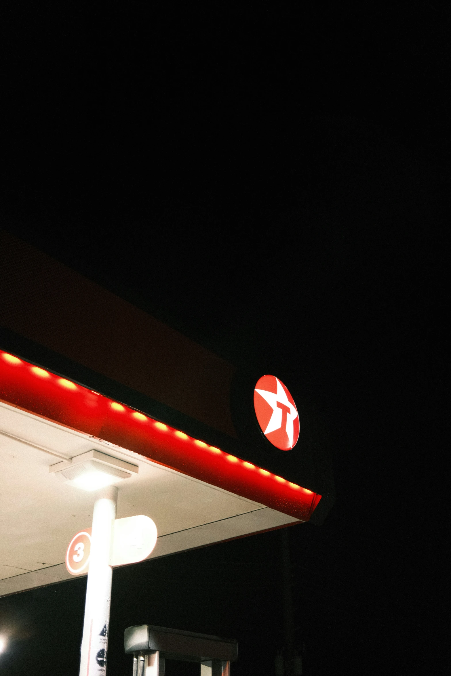 a lighted sign outside of a gas station