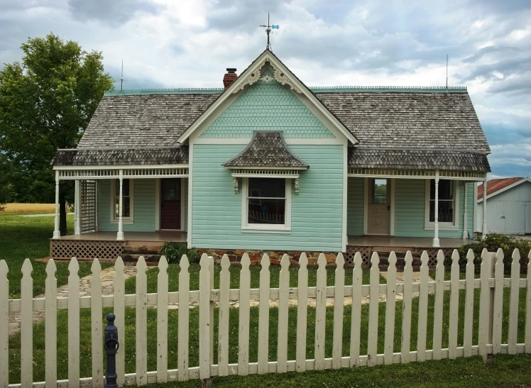 a wooden house with a small picket fence around it