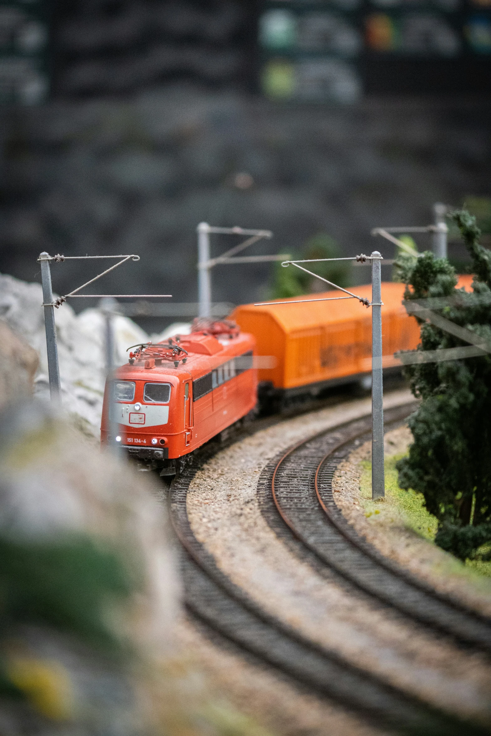 a toy train traveling along tracks with trees on each side