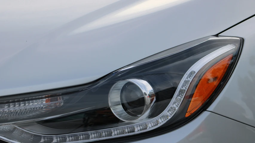 front lights on silver sports car parked in lot