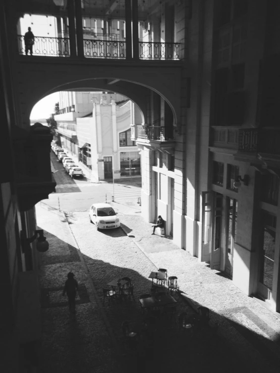 the shadows of cars in a courtyard near an archway