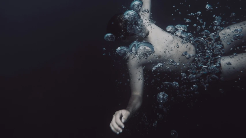 a woman in blue swim trunks underwater