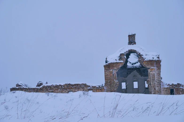 an old stone church stands on a snowy hill