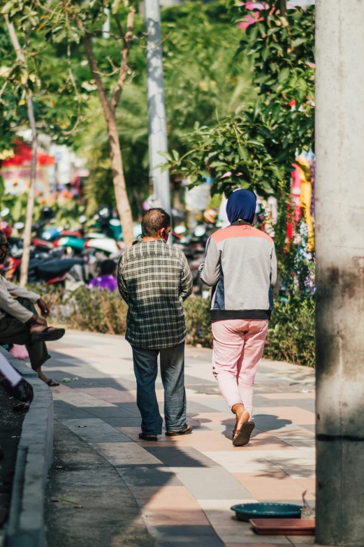 three people walking on the street in one direction