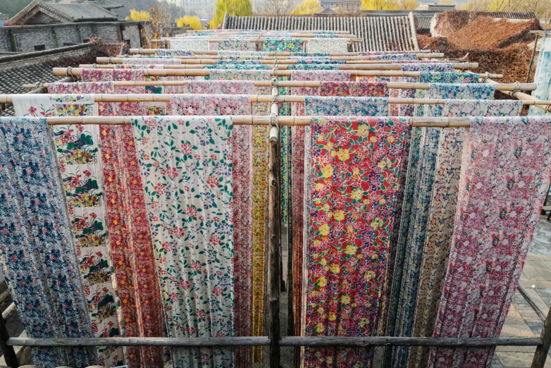 colorful quilts hung up on a metal rack