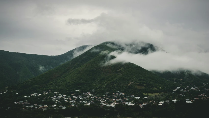 green mountain with fog rolling in front of it