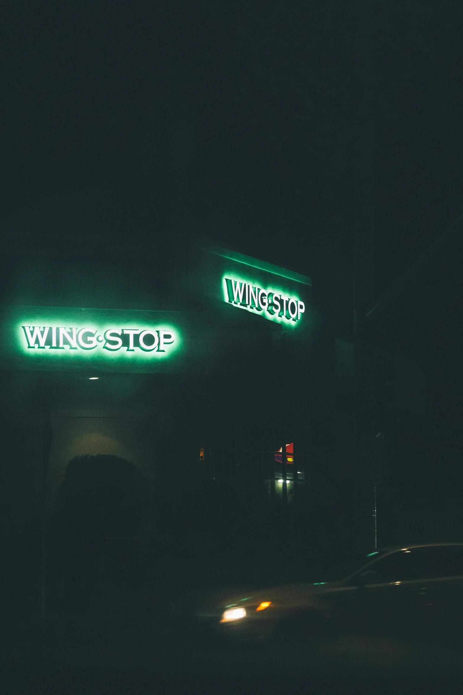a lighted storefront next to the highway at night
