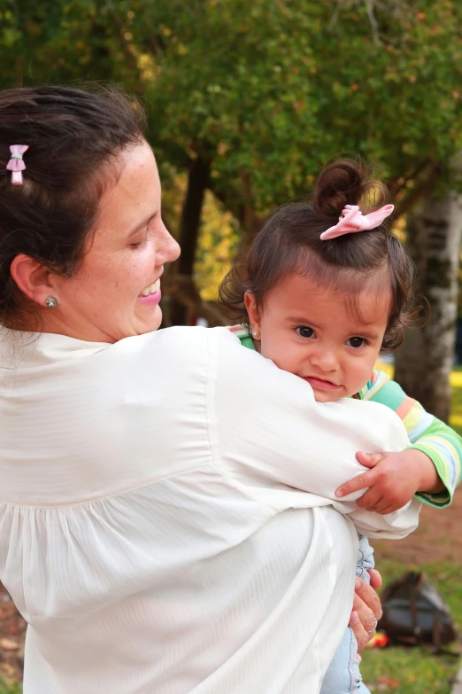 a woman is holding her baby and it looks like she is ing