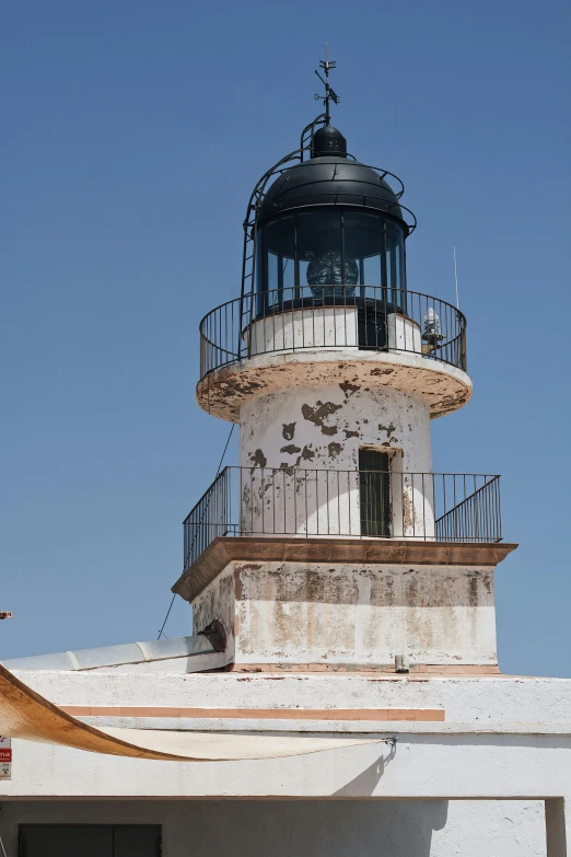 an image of a white lighthouse that is near the ocean