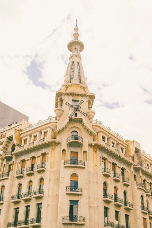 a tall cream colored building with a clock at the top