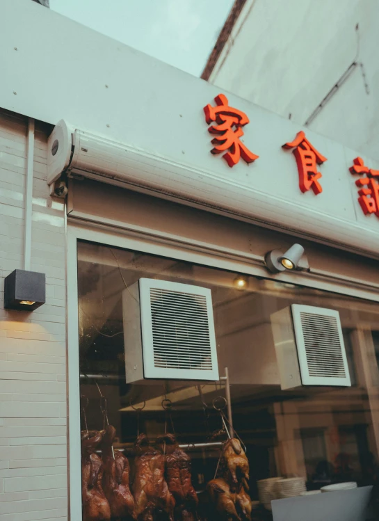 a small restaurant with chinese writing hanging above the windows
