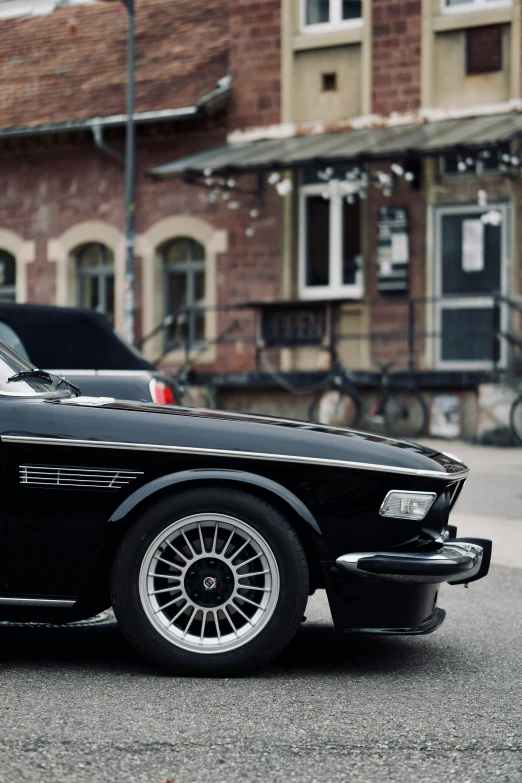 an old car sits parked in front of a building