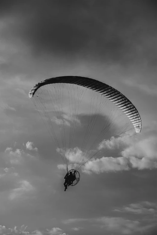 a large parasailer glides in a black and white po