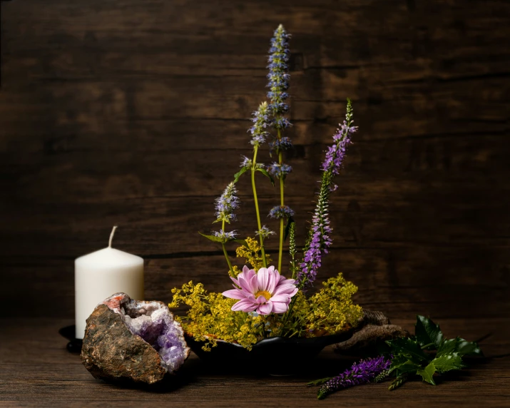 purple flowers, lavenders and a candle are on the table