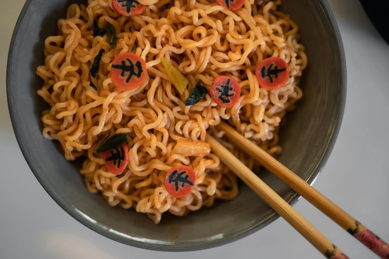 two chop sticks in the noodles with various decorations