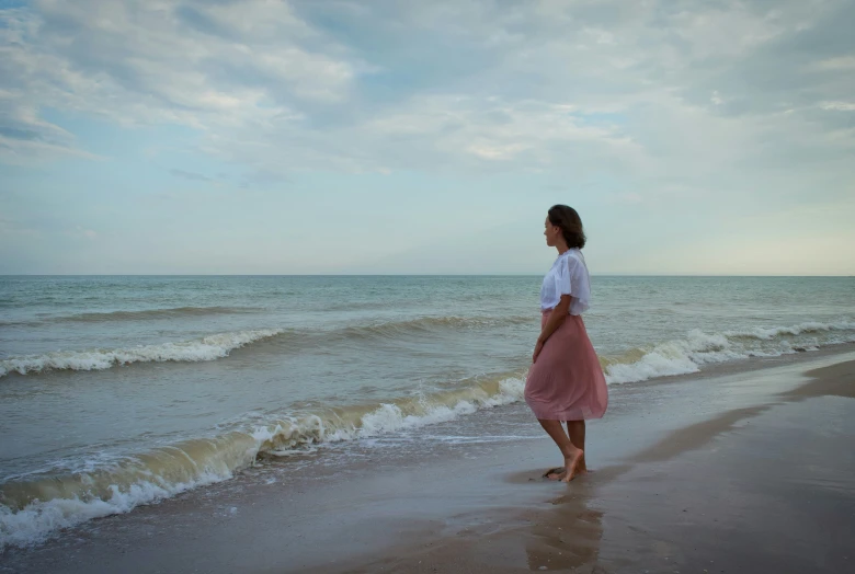 woman walking on the beach in front of crashing waves