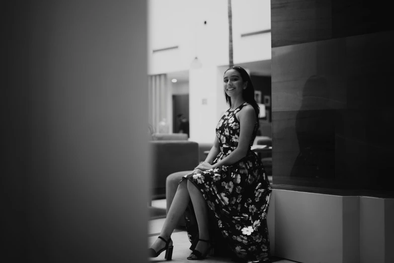 a woman is sitting on the ledge of an office building