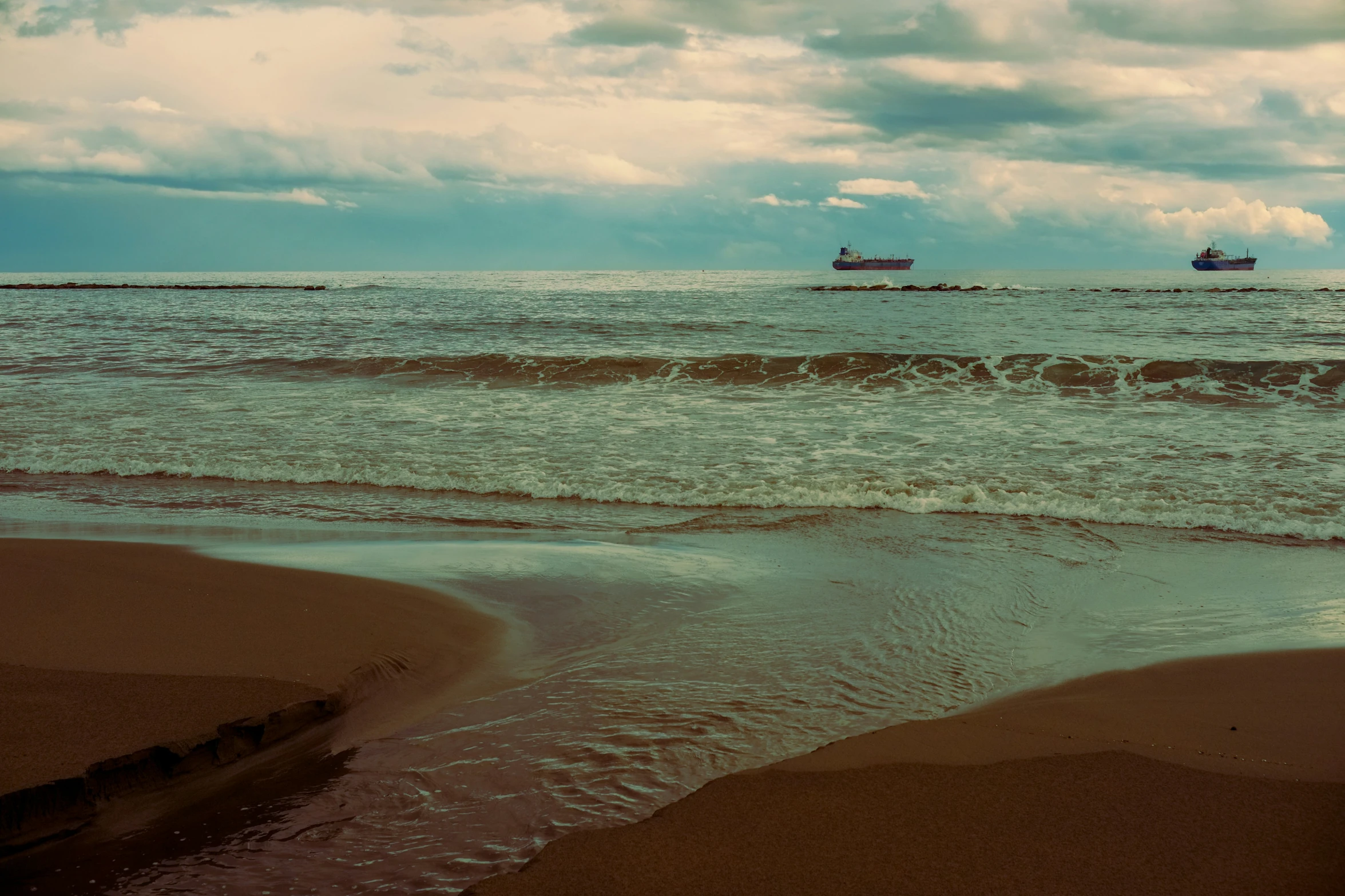 some ships are out on the water near shore