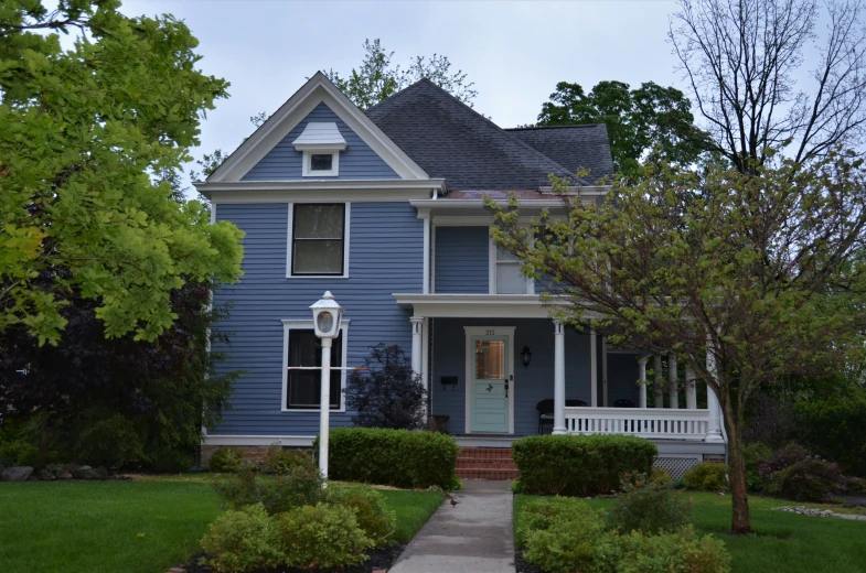 a blue house sitting in the middle of the grass