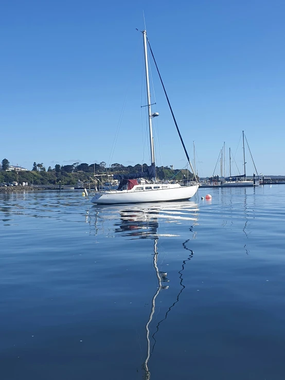 a large white sail boat floating on top of water