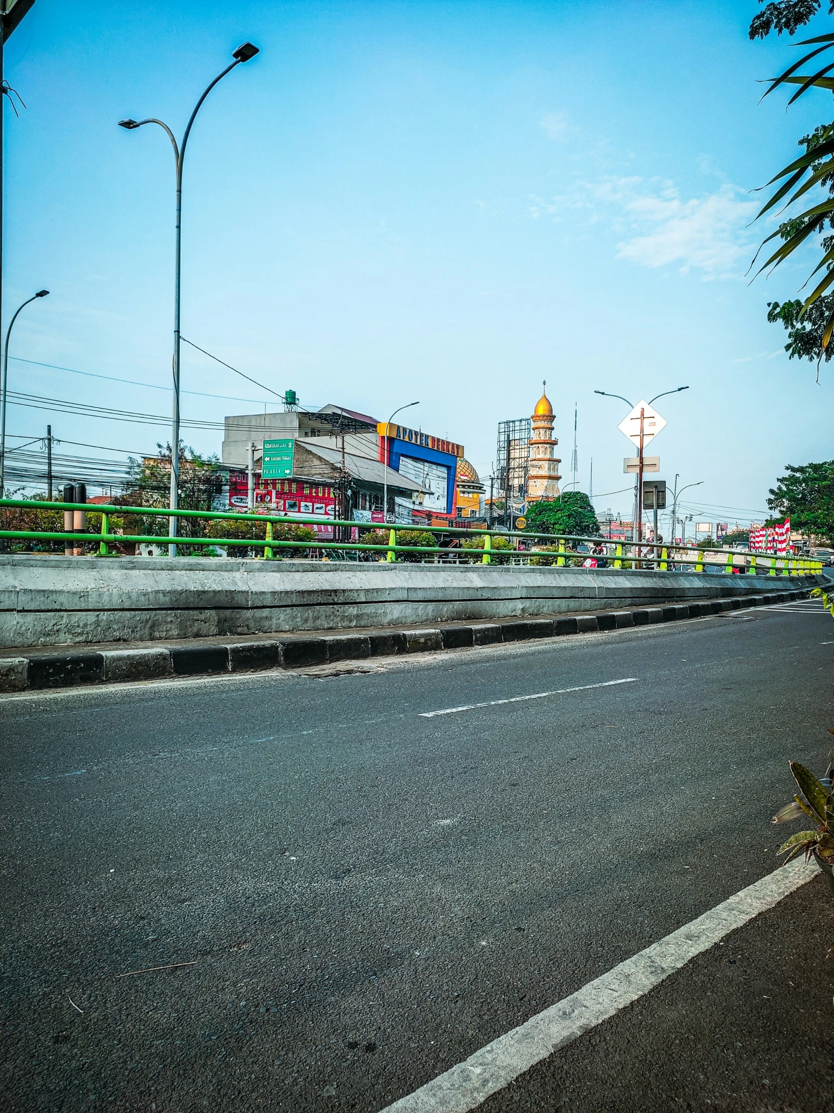 a road next to a very large clock tower in the background