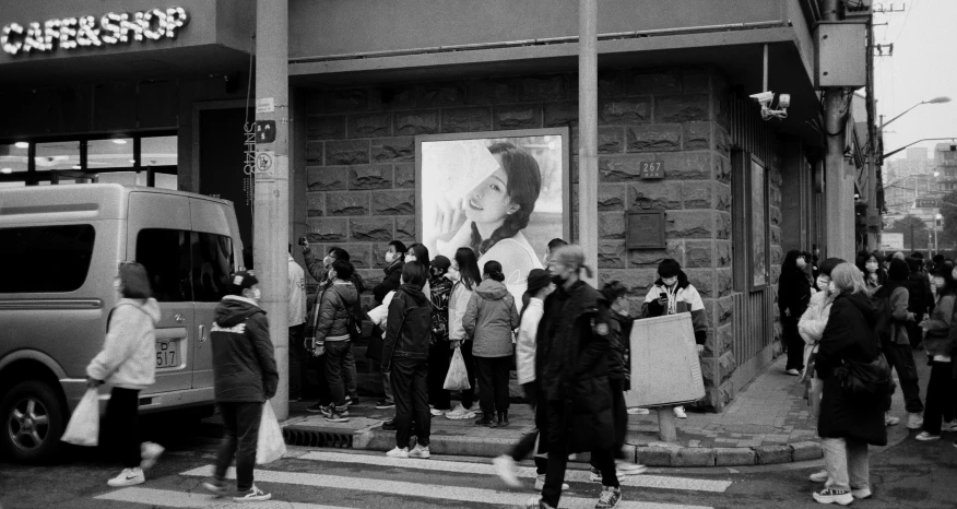 people walking in front of a building with an advertit