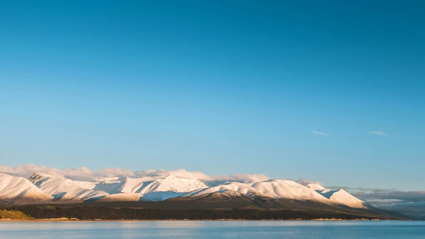 mountains covered in snow above a body of water