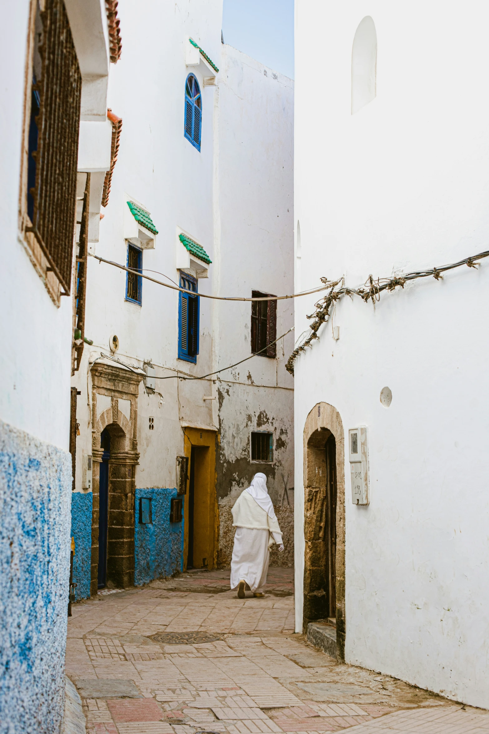 an alley with blue and white buildings next to a door