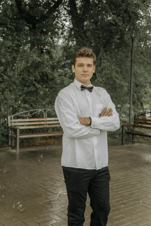 a man is standing near a bench in a park