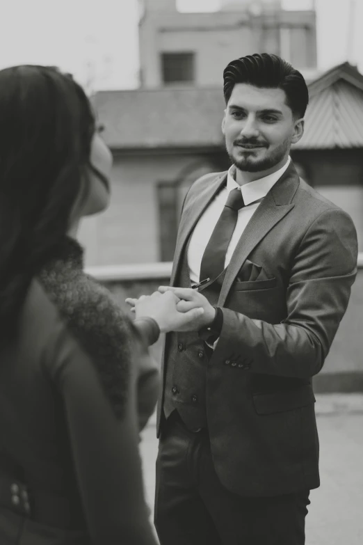 a man in a suit is holding onto his tie