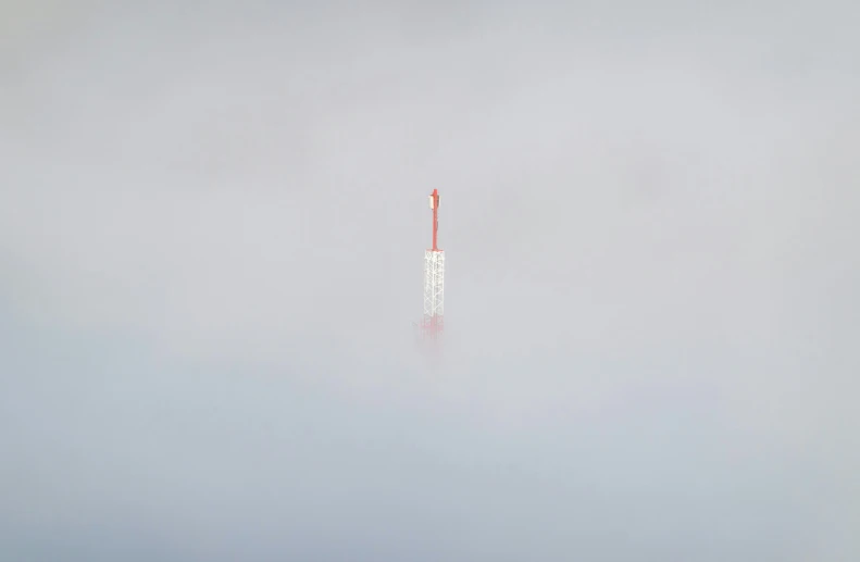 a large white pole sitting in the middle of fog