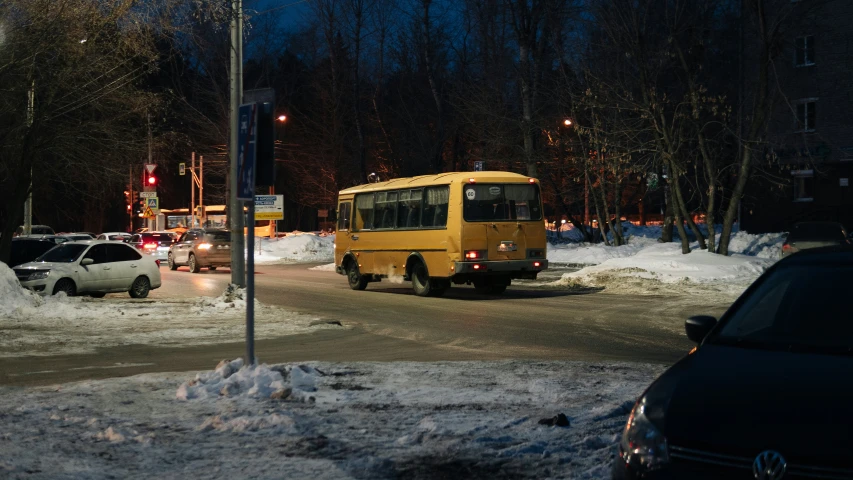 cars, a bus and some trees in the snow