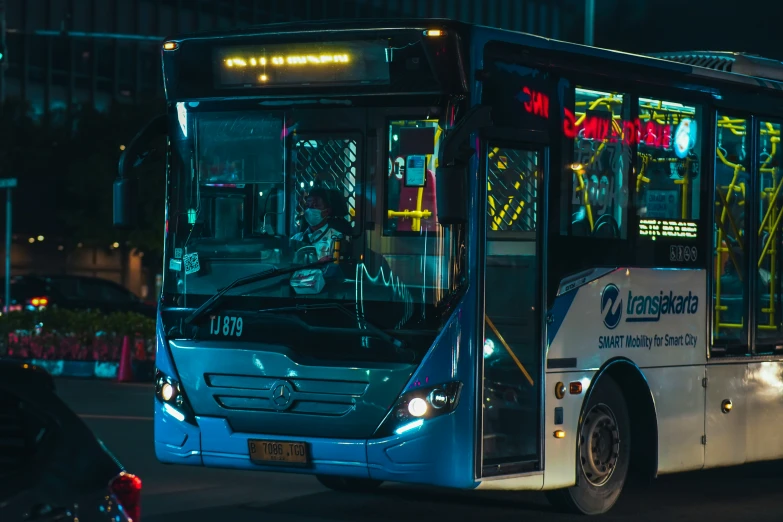 a transit bus is driving down the street at night