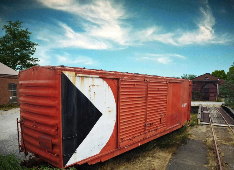 an old red boxcar is painted red, white and black