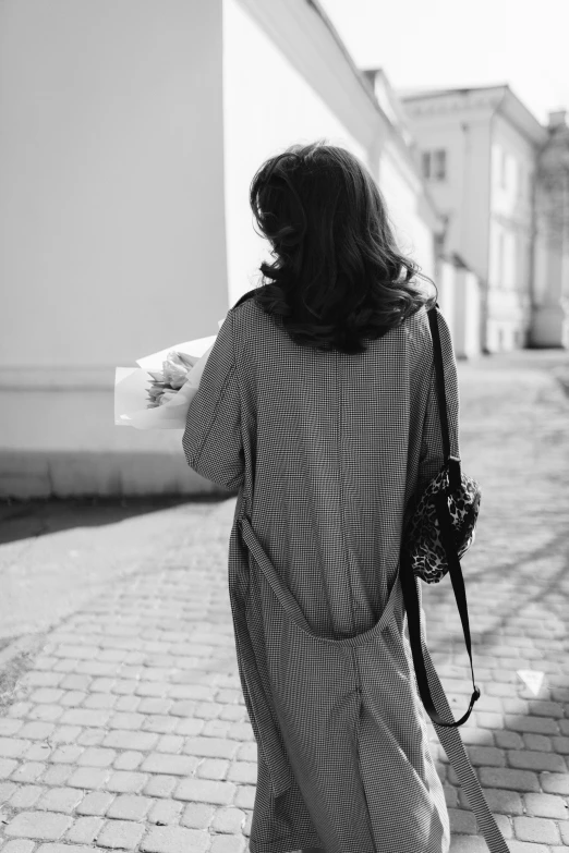 the woman is walking down the sidewalk with a backpack on her back