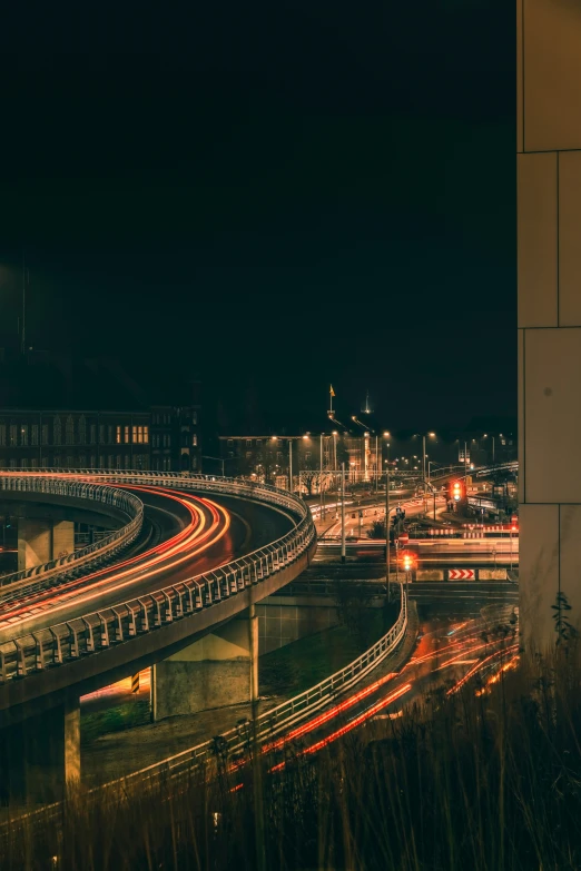 a city street at night with traffic going around