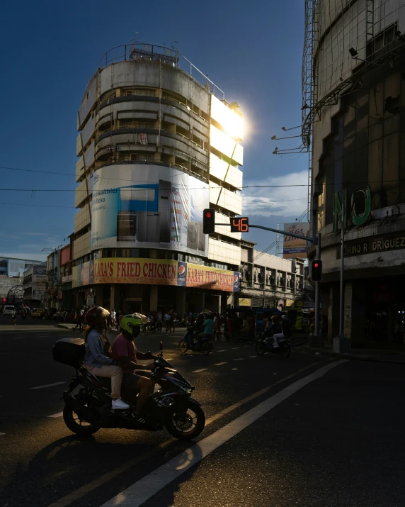 two people on a motor scooter on a city street