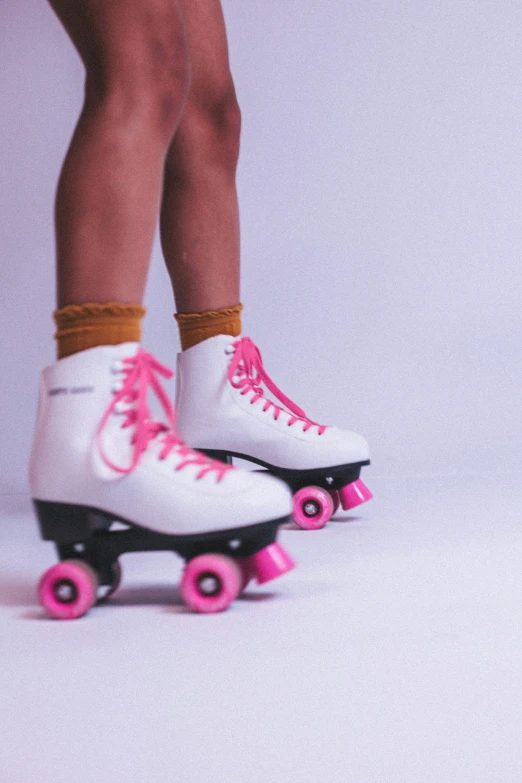 a close - up po of an ice skate with pink wheels