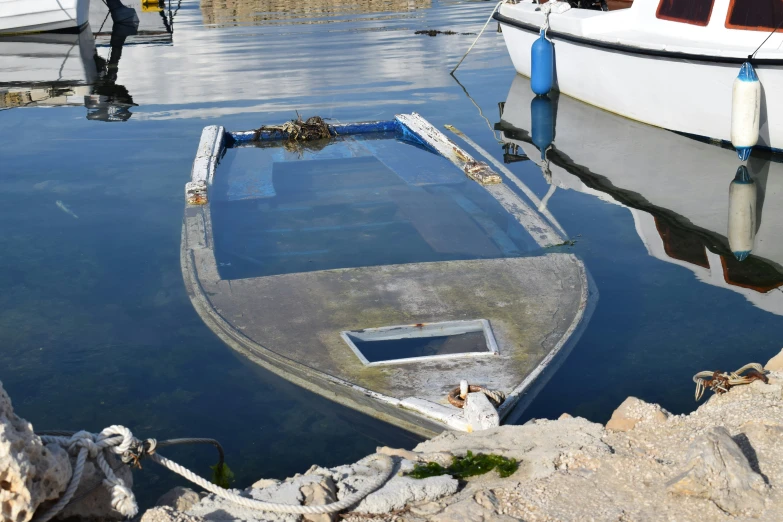 small boat docked at the dock with another boat in the background