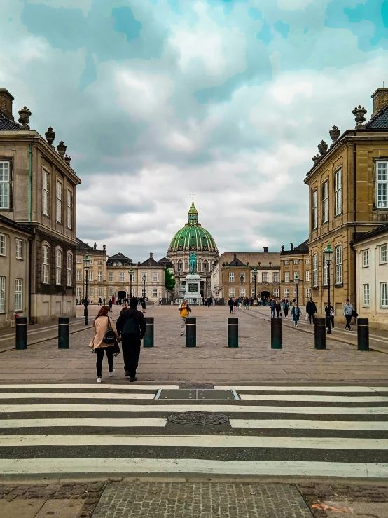 two people walking in front of a very large building