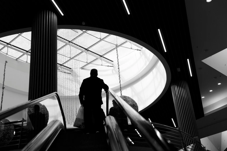 a man standing on an escalator in a large building